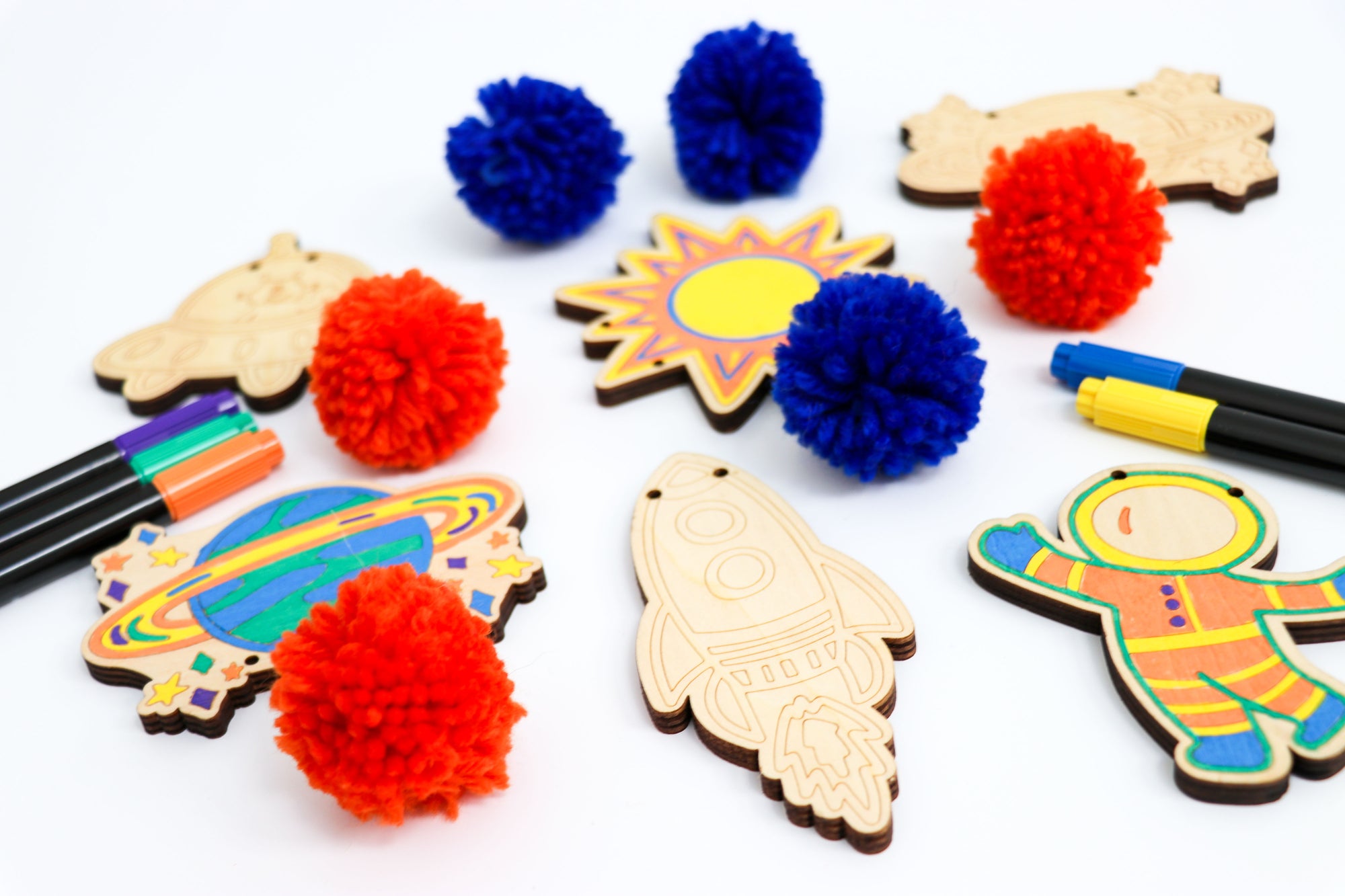 Kids Outer Space Garland Kit being colored - showing all the pieces included as well as pom poms and markers.