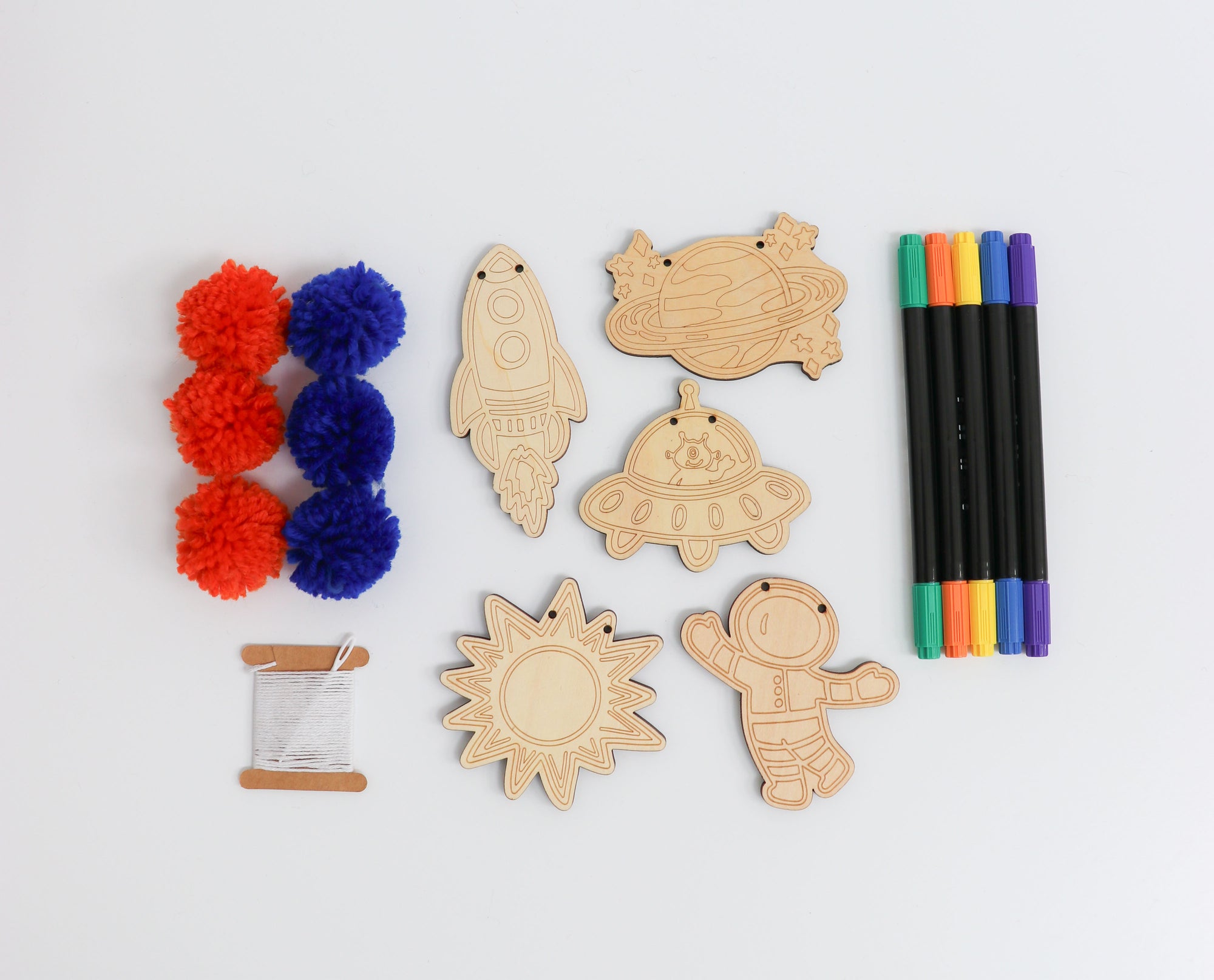 Contents of the Kids Outer Space Garland Kit with wooden shapes, pom-poms, and markers