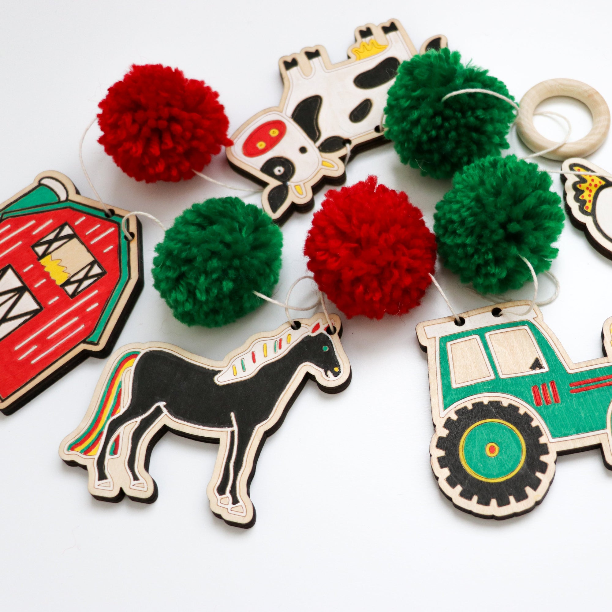 Set of colorful farm-themed wooden pieces to color with pom-poms on a white background - garland kit by Woodsy Craft Co.